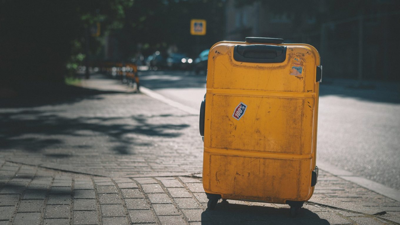 yellow plastic trash bin on sidewalk during daytime
